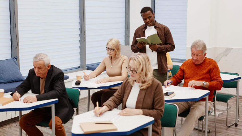 Adultos séniores sentados a aprender numa escola
