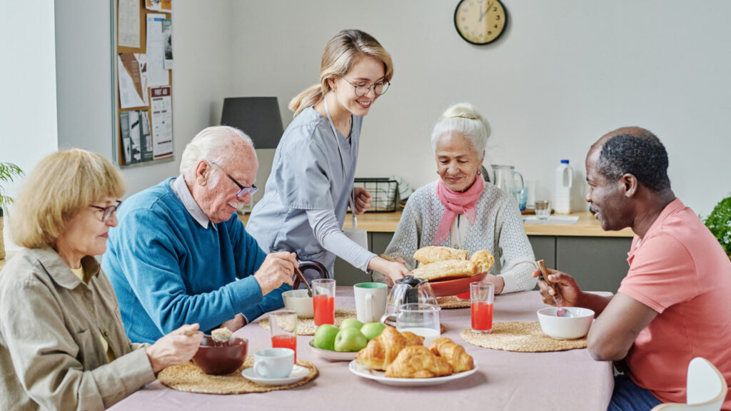 Idosos sentados à mesa a comer