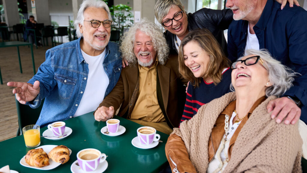 Grupo de idosos a divertir-se e a lanchar todos juntos